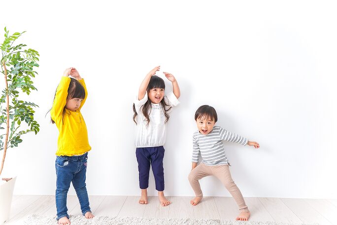 教師と一緒に英語を学ぶ幼児のイメージ